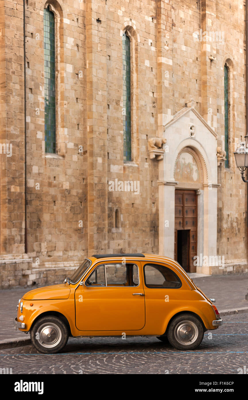 Orange classique voiture italienne devant une église catholique Banque D'Images