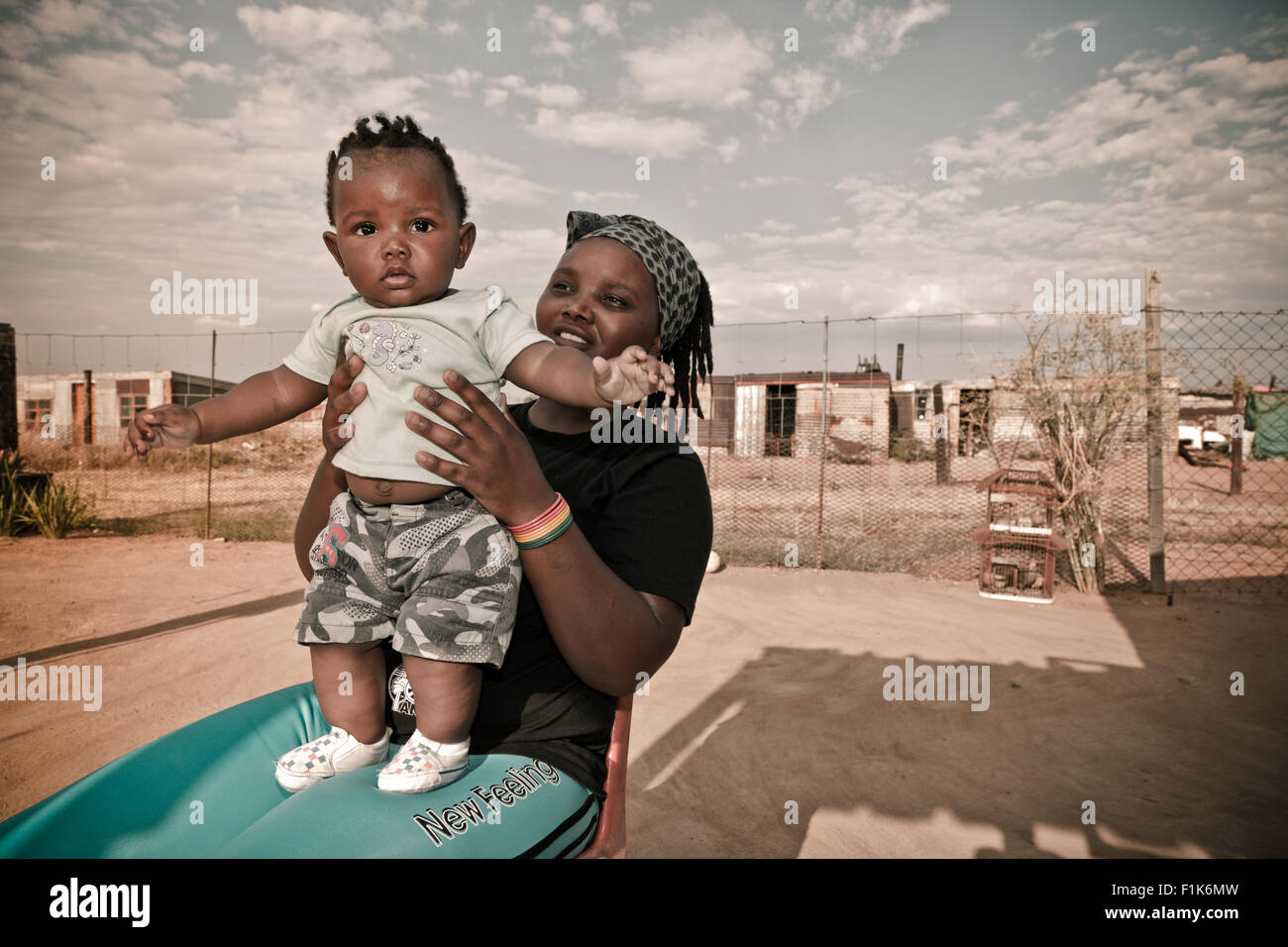 Jeune femme africaine se trouve à l'extérieur tenant un petit garçon Banque D'Images