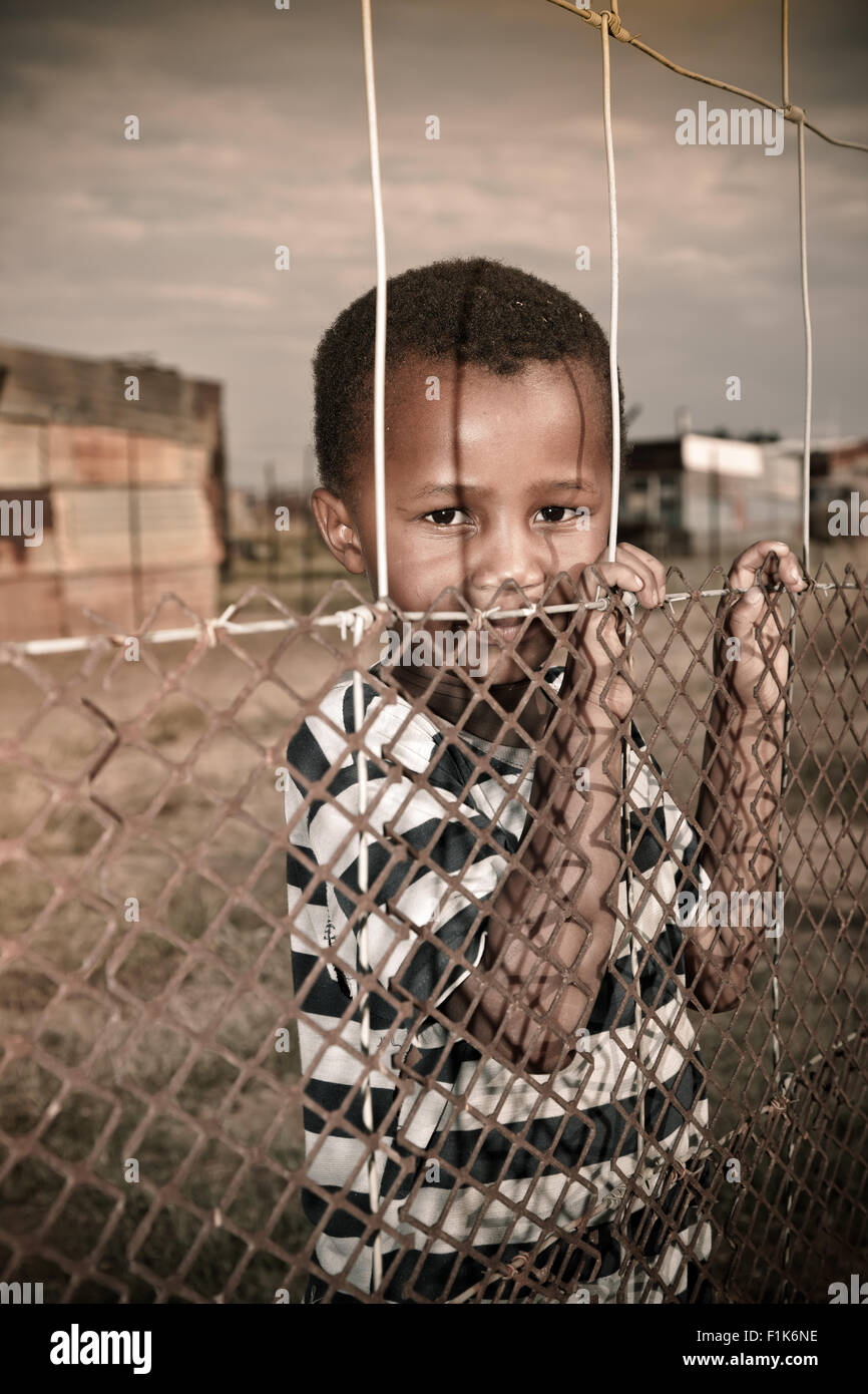 Jeune garçon africain se trouve à la barrière, looking at camera Banque D'Images