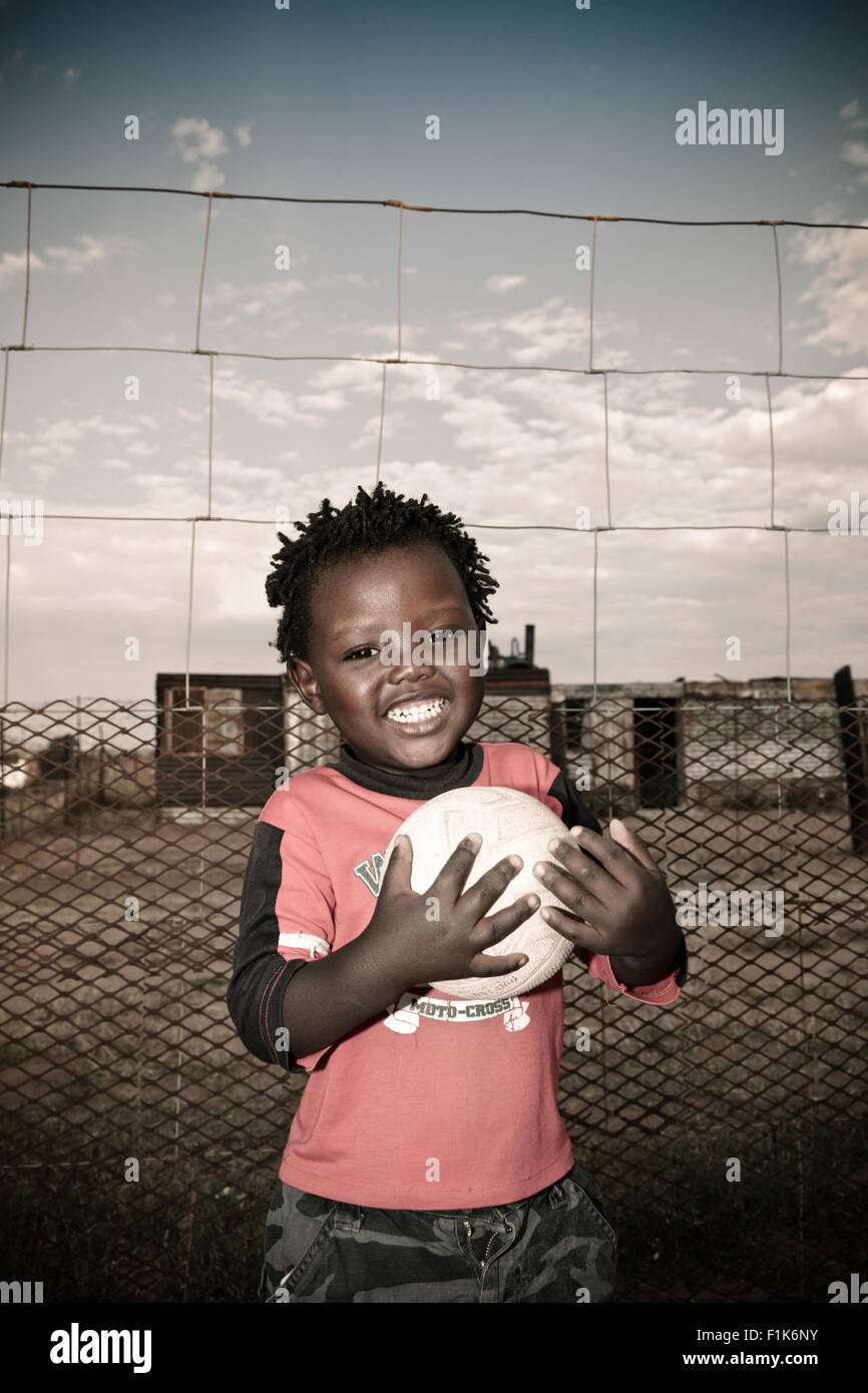 Jeune garçon africain se trouve à l'extérieur, smiling at camera Banque D'Images