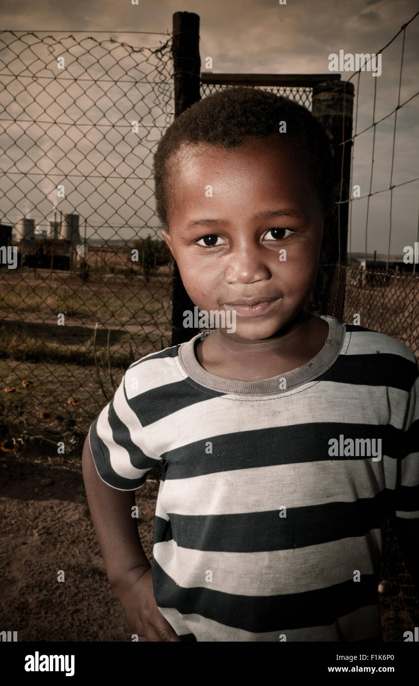 Jeune garçon africain se trouve à l'extérieur, smiling at camera Banque D'Images
