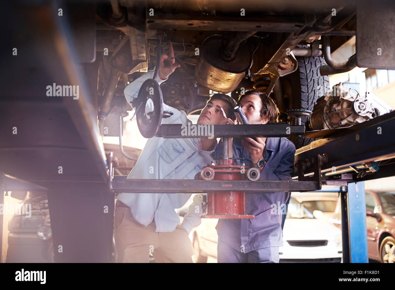 Mécanicien et le client dans le cadre de la voiture en atelier de réparation automobile Banque D'Images