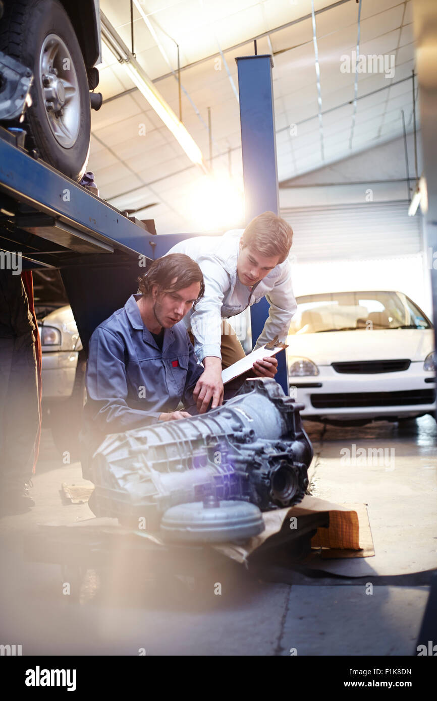 Mécanicien et de l'examen du client dans la partie moteur auto repair shop Banque D'Images