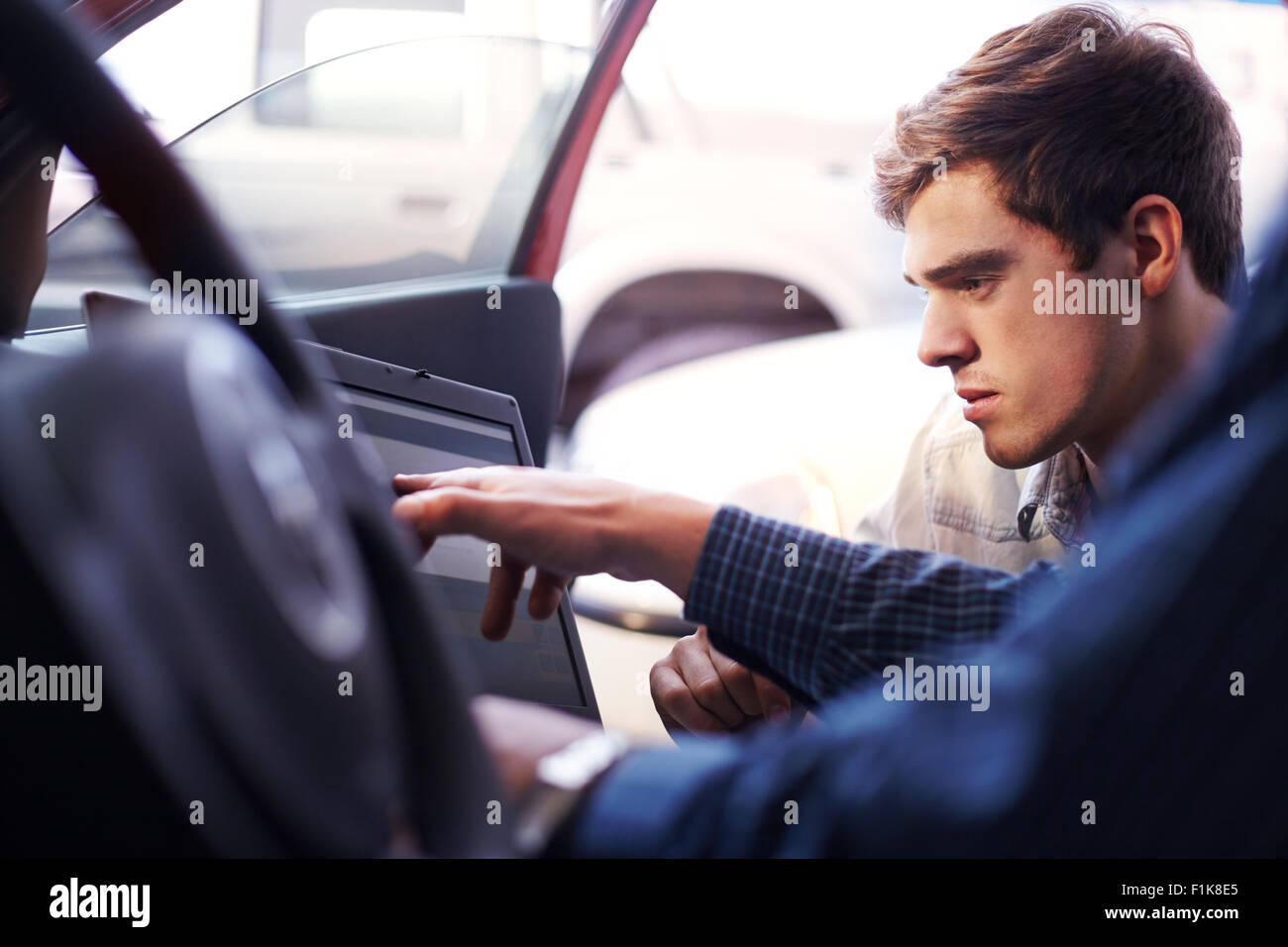 Mécanicien et client avec coffre à l'intérieur de voiture Banque D'Images