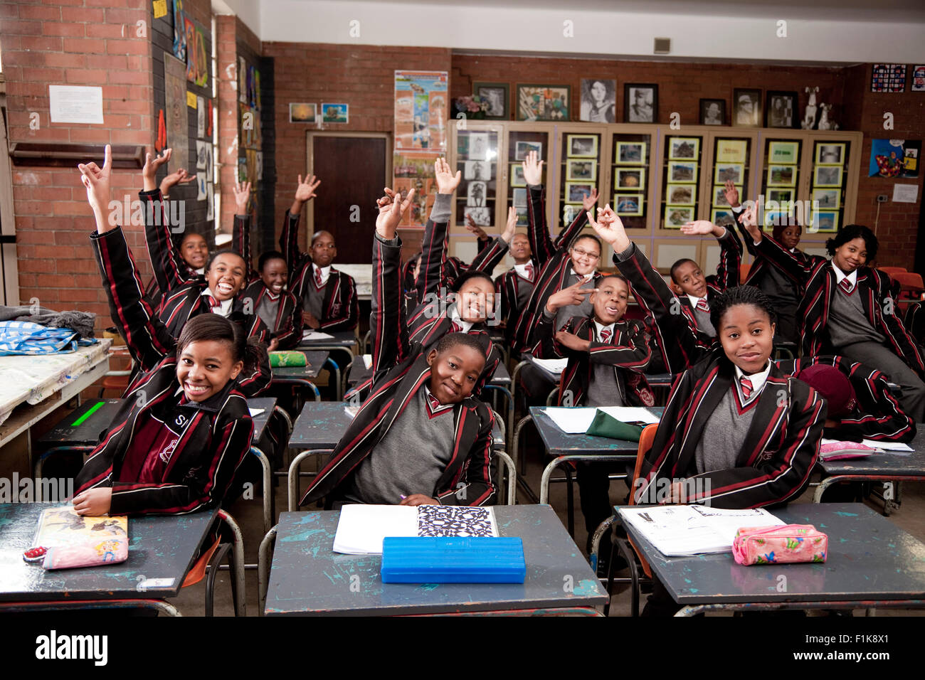 Une vue d'ensemble d'une classe pleine d'élèves lèvent la main Banque D'Images
