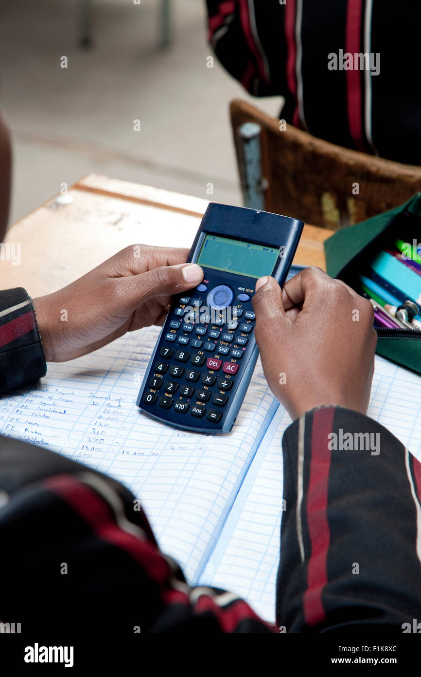 Gros plan d'un élève du secondaire's hands holding une calculatrice Banque D'Images