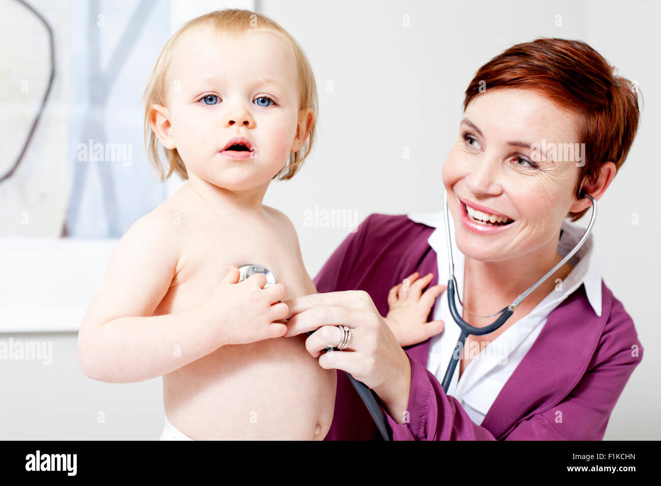Un pédiatre à l'écoute de la respiration d'un bébé Banque D'Images