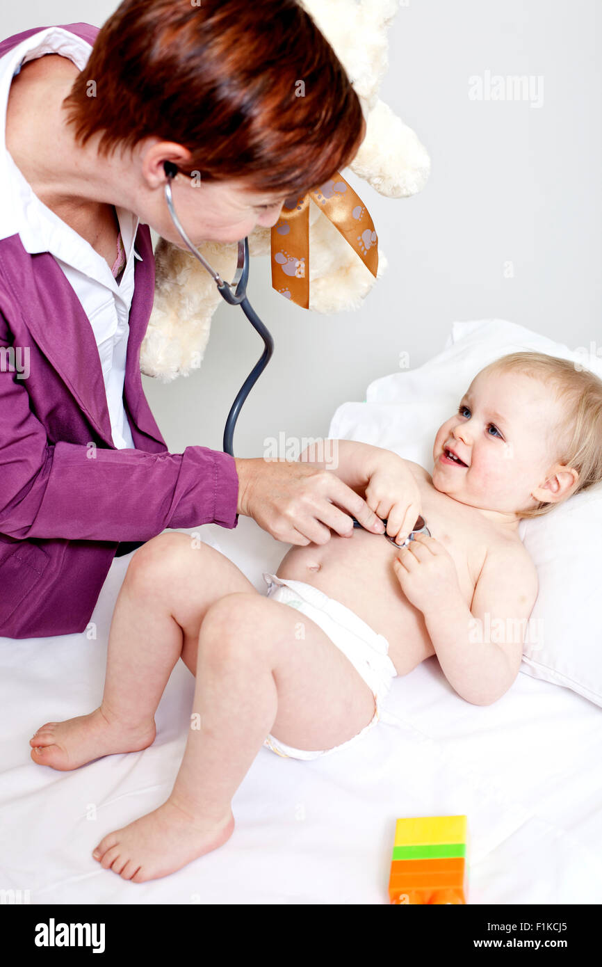 Un pédiatre à l'écoute de la respiration d'un bébé Banque D'Images