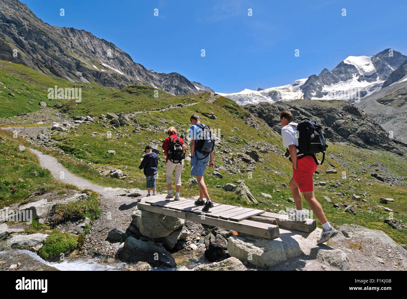 Les marcheurs / les randonneurs à marcher le long du chemin de montagne vers le glacier de Moiry dans les Alpes Pennines, Valais / Wallis (Suisse) Banque D'Images