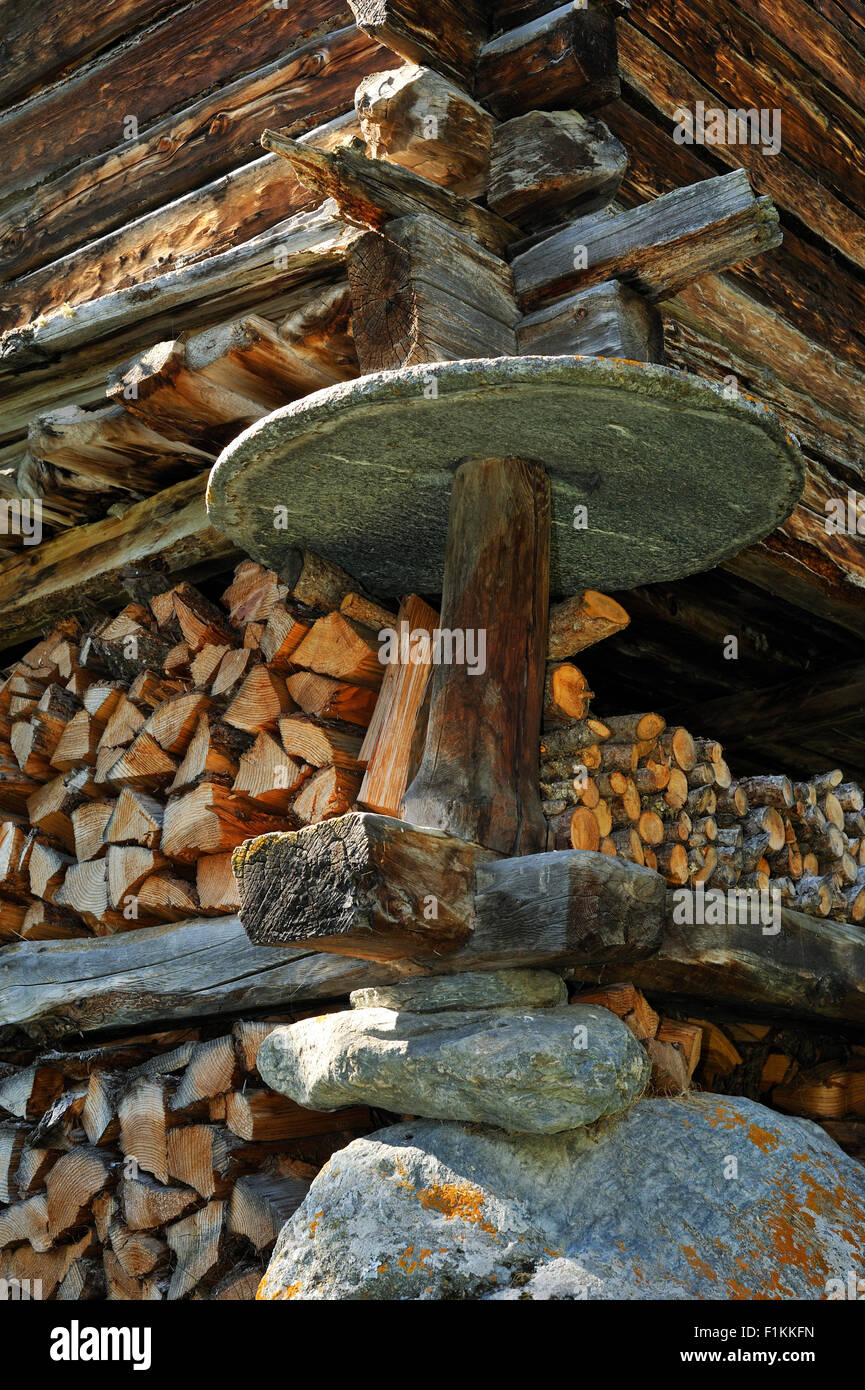 Détail de grenier traditionnel en bois / raccard montrant dalle de pierre circulaire pour empêcher les rongeurs d'avoir accès au grain Banque D'Images