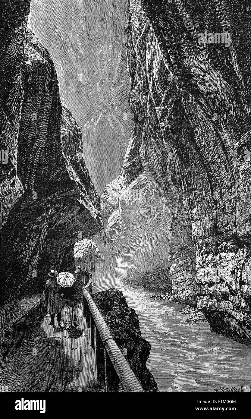 Touristes du XIXe siècle sur un passage au-dessus d'une rivière dans un ravin dans les Alpes suisses. Banque D'Images