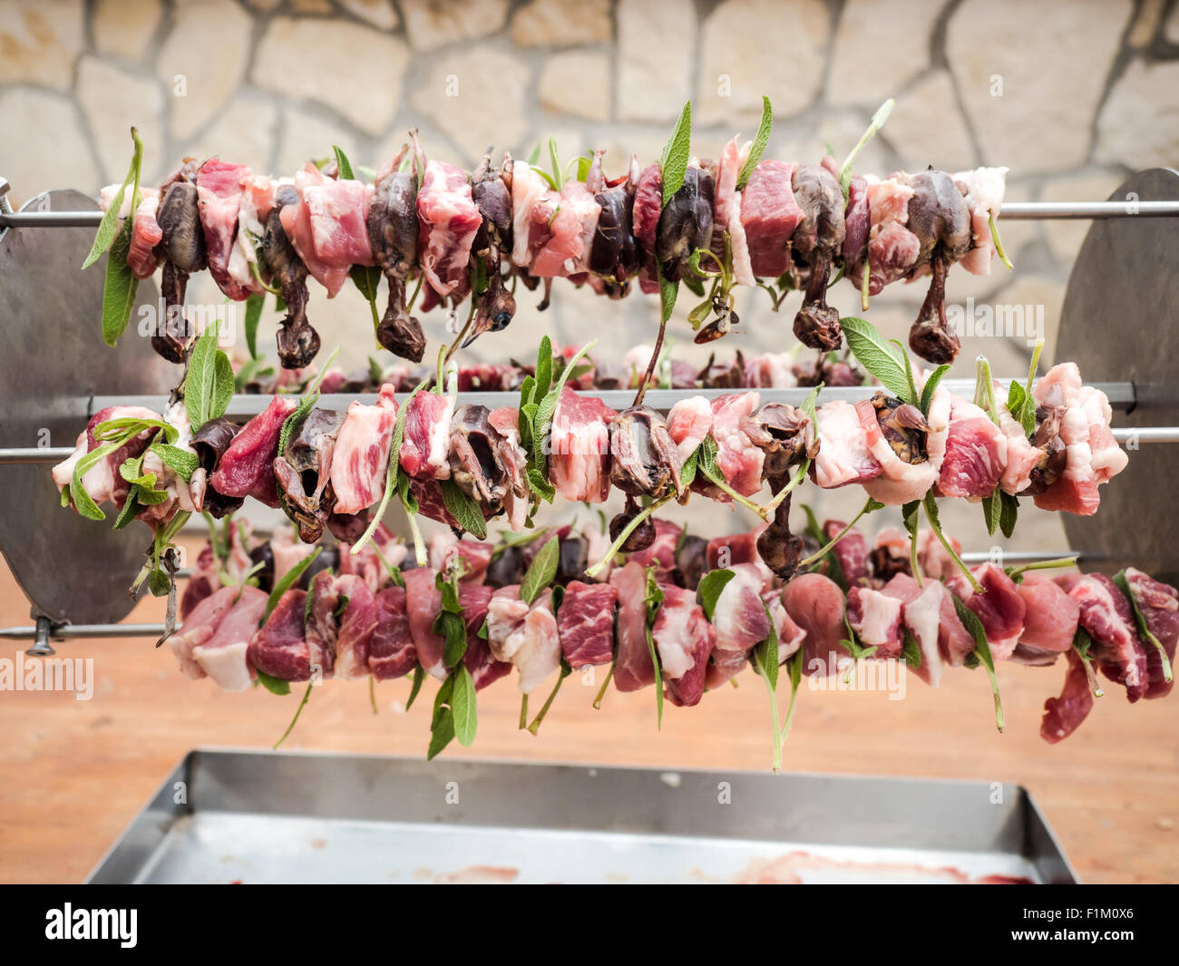Les oiseaux sur la flèche avec la viande, bacon et sage prêt pour la cuisson Banque D'Images