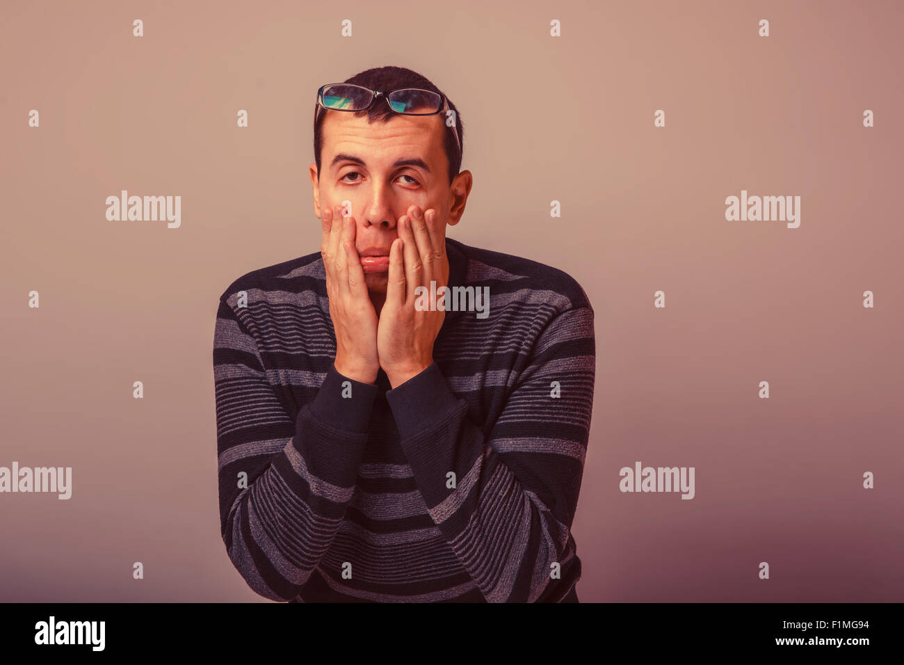 Homme d'apparence des cheveux noirs s'étire les yeux avec son h Banque D'Images