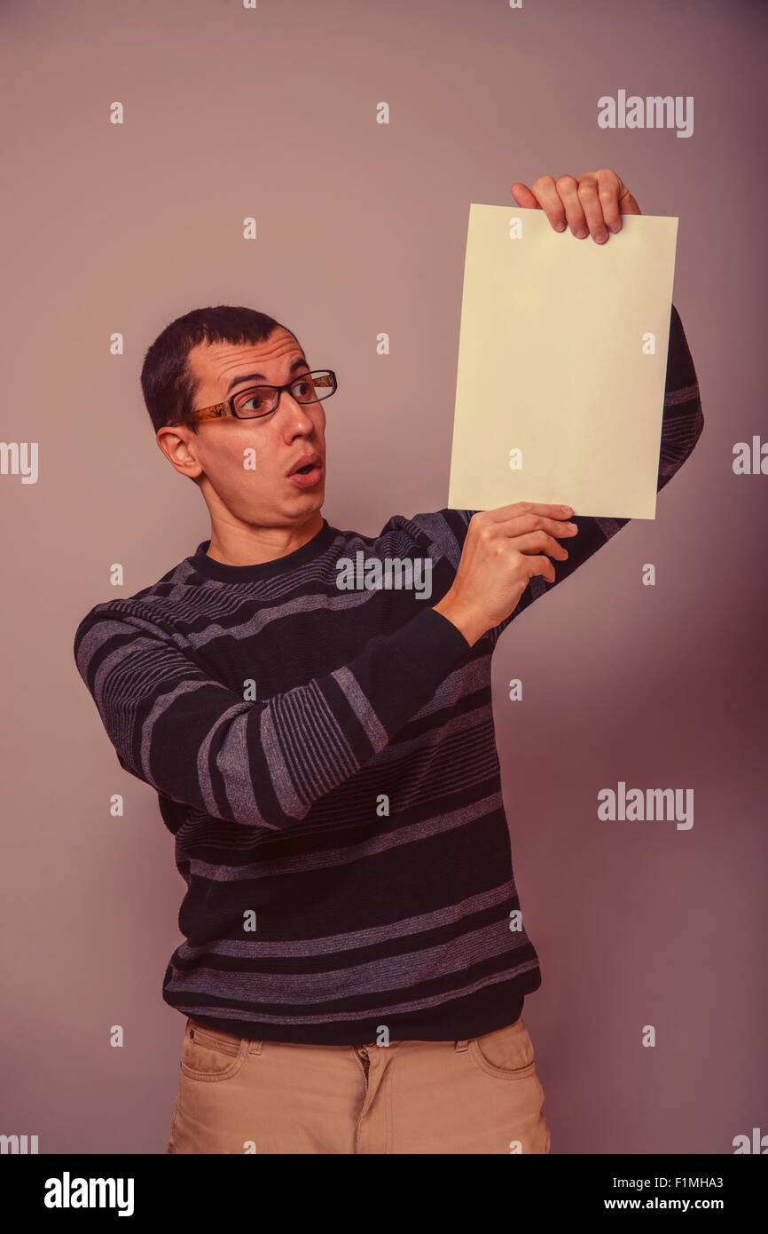 Homme à l'Européen de 30 ans tenant une feuille vierge, surprise ! Banque D'Images