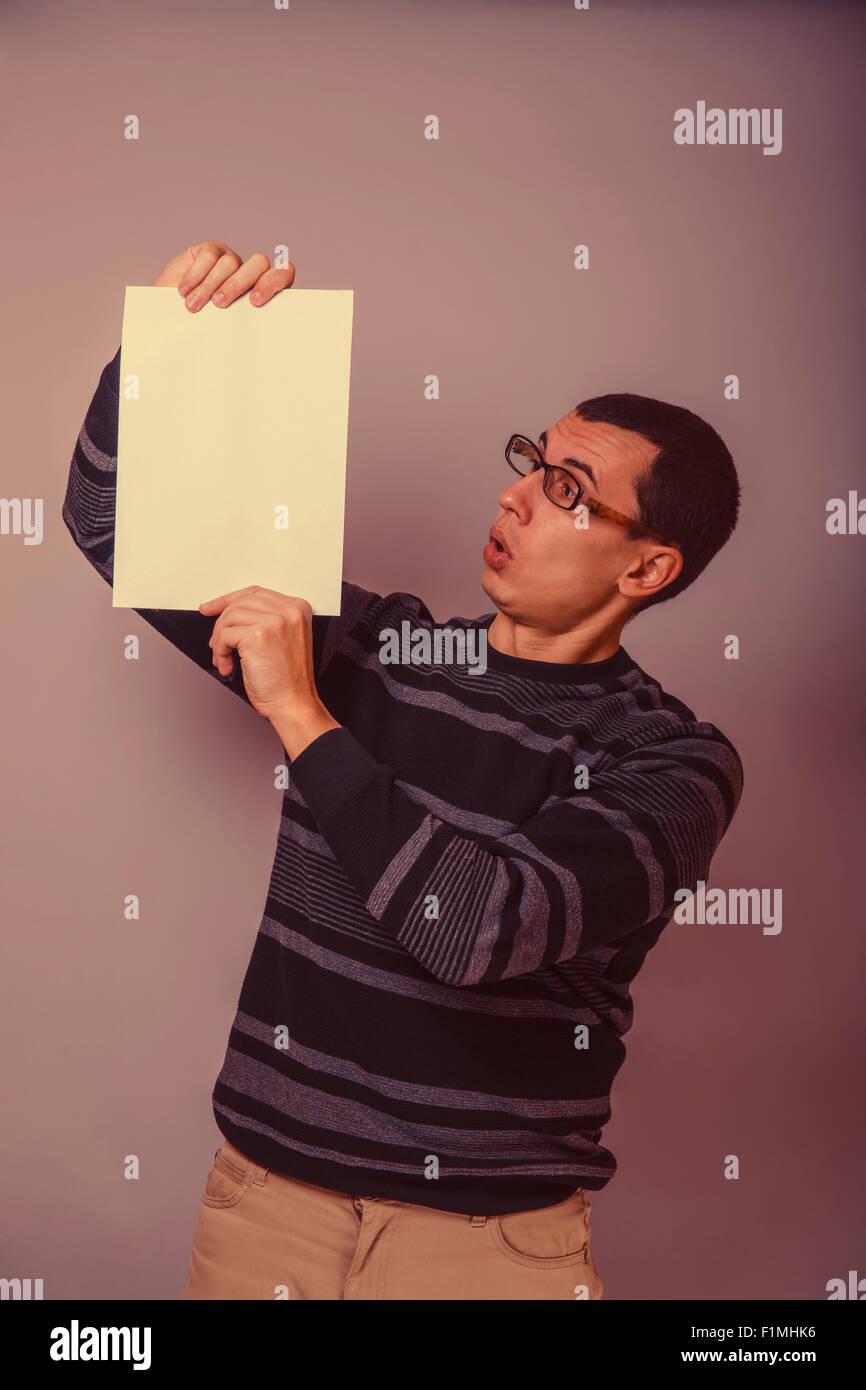 Homme à l'Européen de 30 ans tenant une feuille vierge, surprise ! Banque D'Images