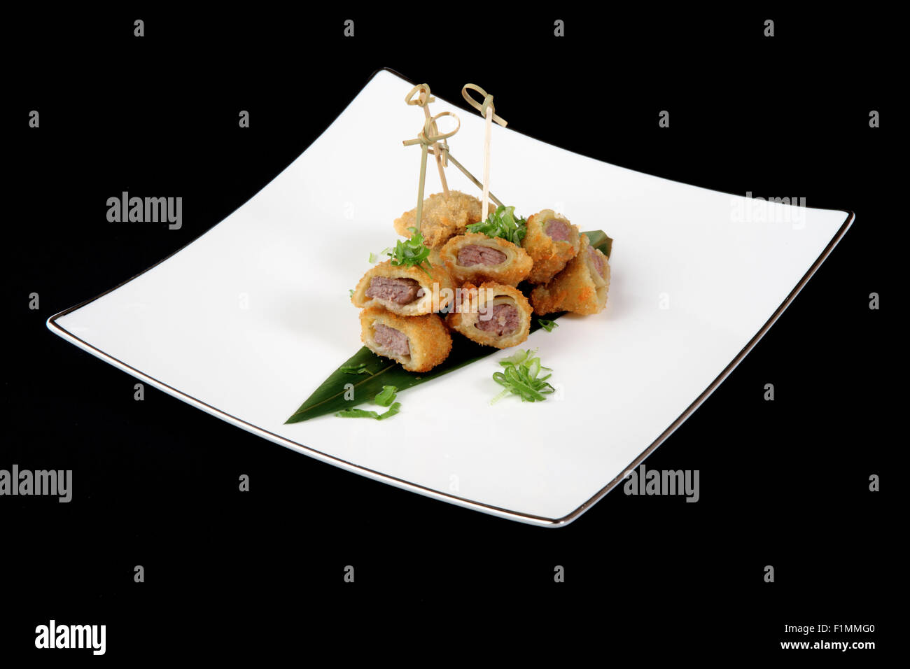 Filets de poisson avec légumes en plaque blanche sur fond noir Banque D'Images