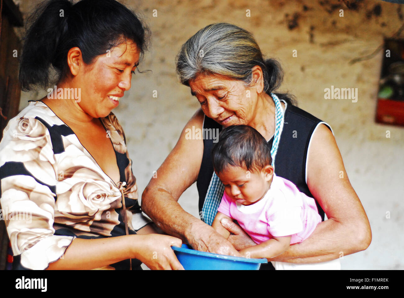 Guatemala, Los Achiotes, mère et grand-mère se laver les mains de bébé (Gudelia Lopez, 69 ans ; Ana de Jésus Rodriguez Lopez 35 ans et bébé Cristel Yuseth Rodriguez Lopez 9 mois) Banque D'Images