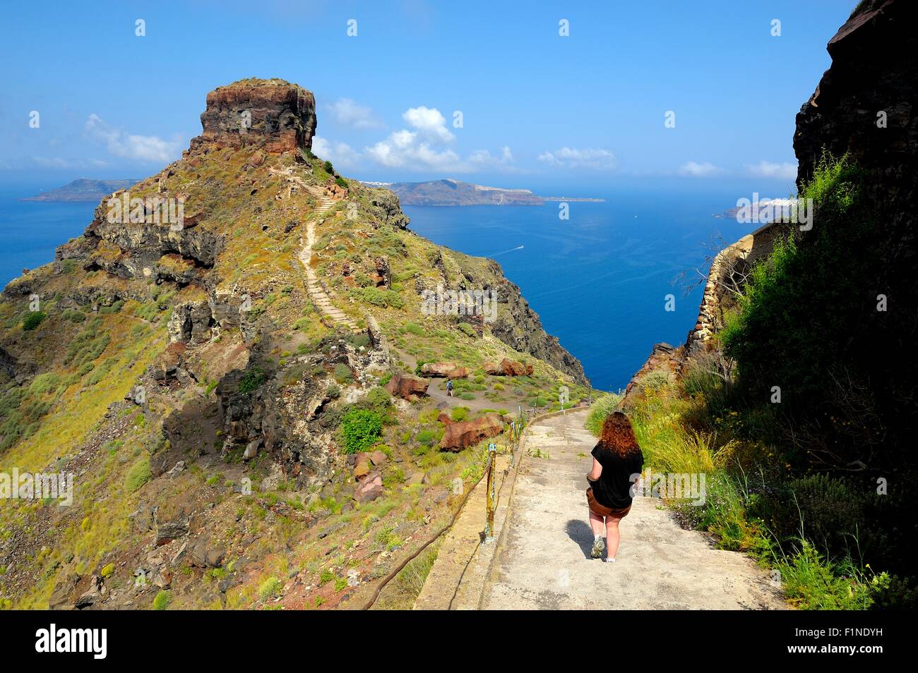Une femme marche touristique sur le chemin de Skaros rock Imerovigli Santorini Grèce Banque D'Images