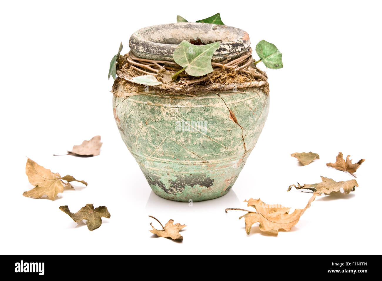 Rustique vieux pot en argile avec des feuilles isolées sur fond blanc Banque D'Images