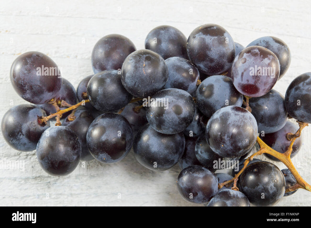 Grappe de raisins sur table en bois blanc Banque D'Images