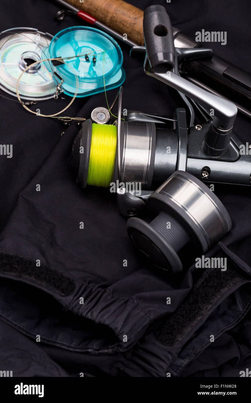 Matériels de pêche - canne, moulinet, leurre et ligne sur fond noir jacket Banque D'Images