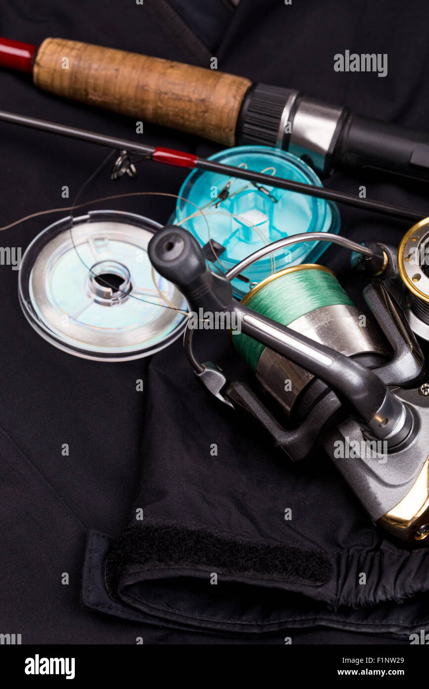 Matériels de pêche - canne, moulinet, leurre et ligne sur fond noir jacket Banque D'Images