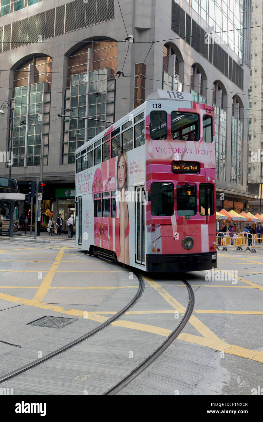 HK Hong Kong emblématique tramway. Tramway sur un virage incliné donnant la perspective. Passant sur un quadrillage jaune sur la route. Banque D'Images
