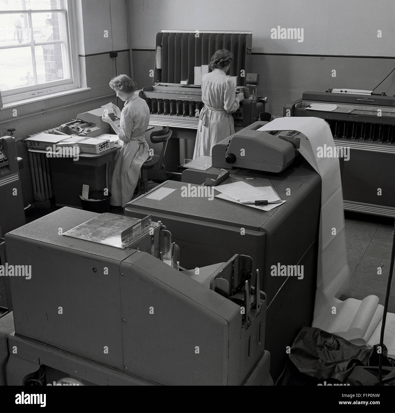 Années 1950, historique, social, avec les secrétaires ou assistants comptables ou les commis au travail à l'aide de diverses méthodes comptables l'enregistrement des données d'IBM ou de machines et imprimantes. Banque D'Images