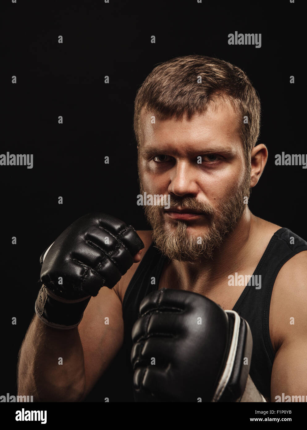 Athletic boxer barbu avec des gants sur fond sombre Banque D'Images