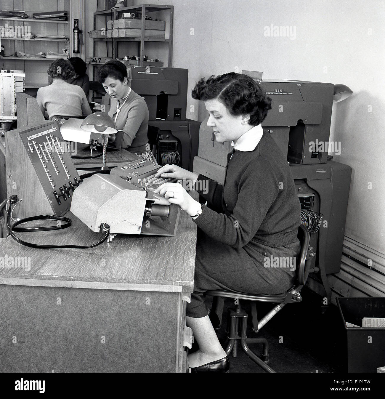 Historique, 1950, photo montrant un bureau, avec les secrétaires ou assistants comptables ou les commis au travail à l'aide de diverses machines. Banque D'Images