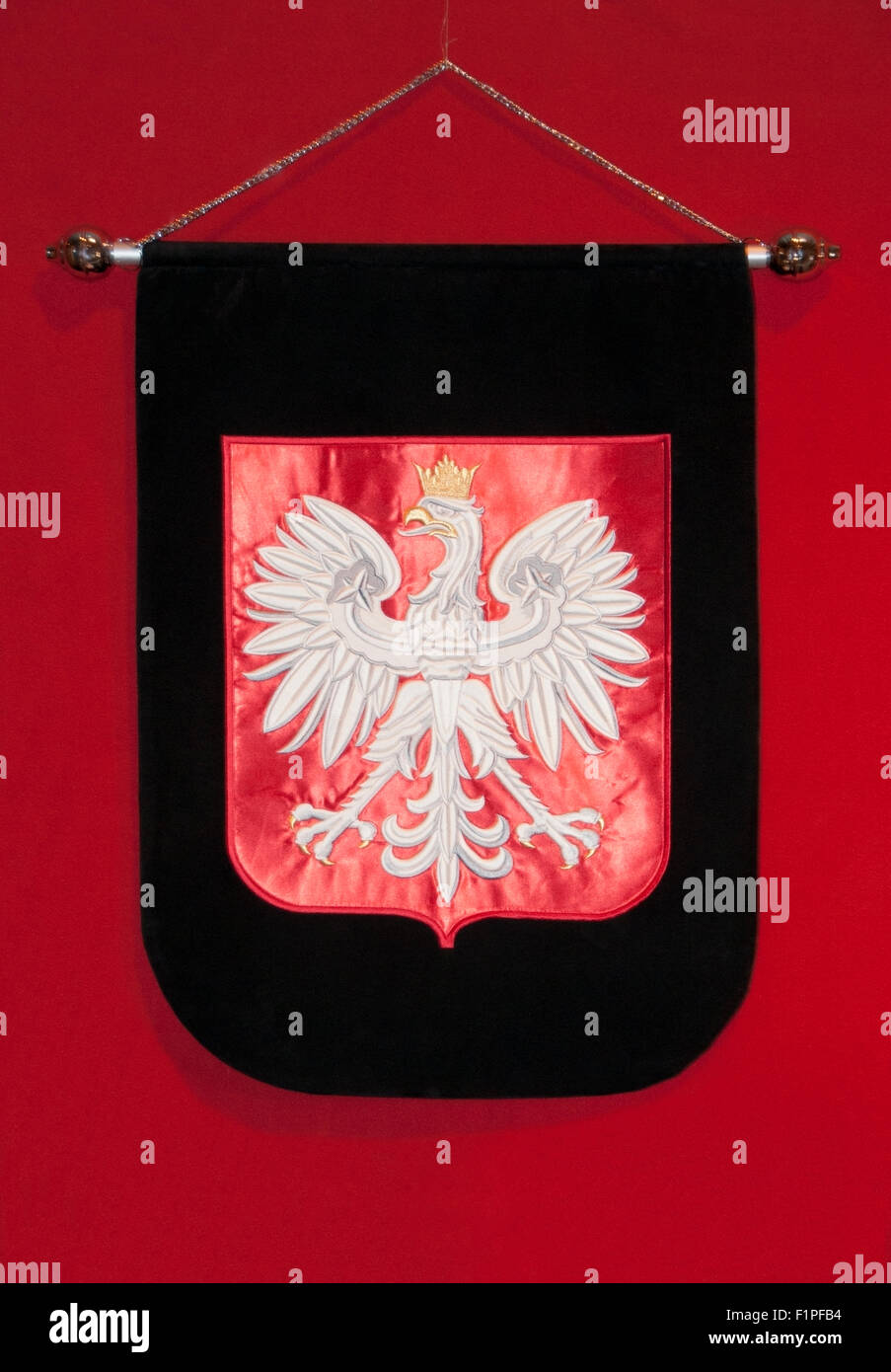 L'emblème de l'aigle polonais, avec une couronne jaune, brodé sur un tissu de velours rouge, sur fond rouge et noir, Polska, polonaise, PL Banque D'Images
