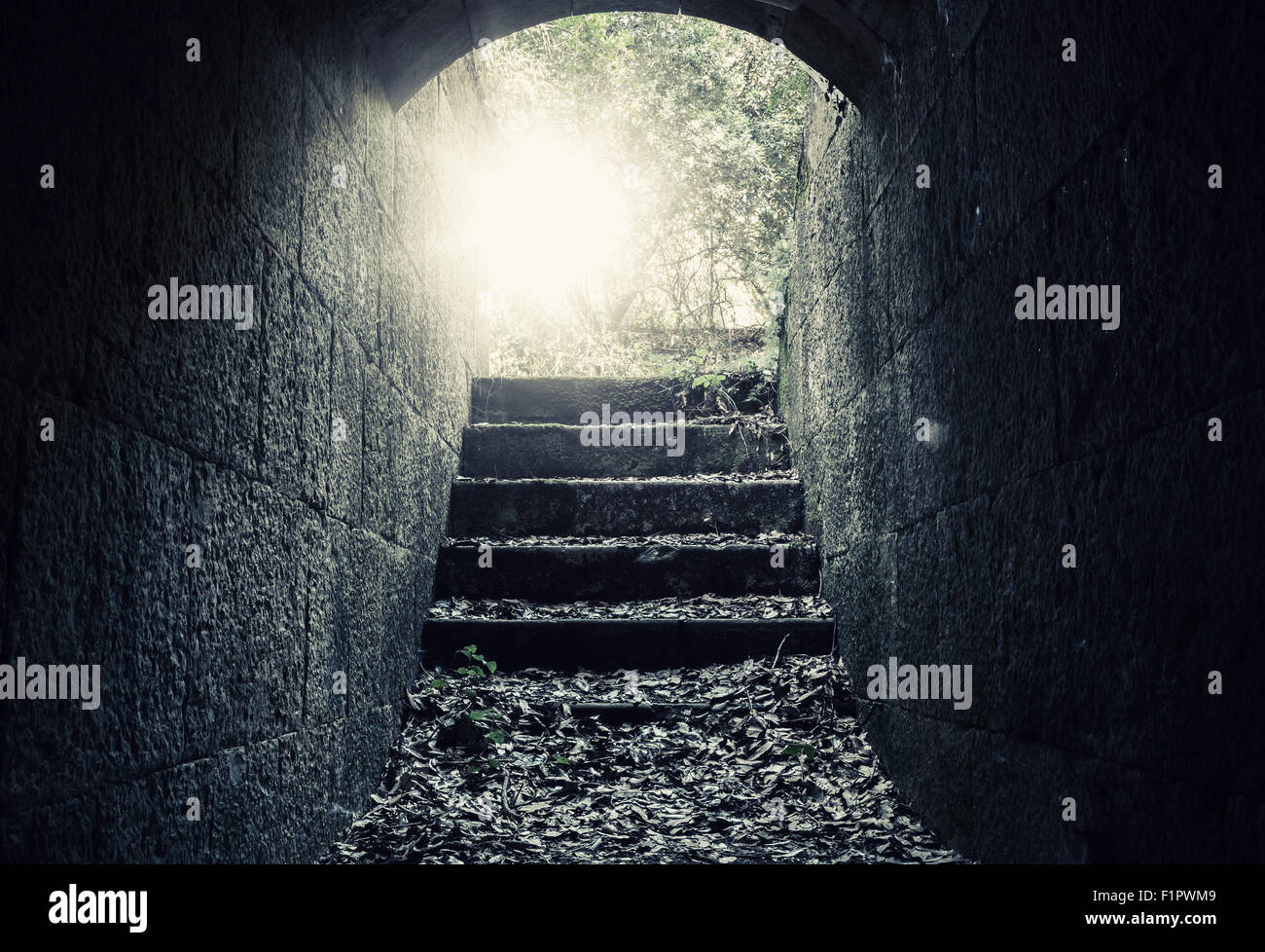 Sortie rayonnante avec des escaliers et des reflets de l'obscur tunnel en béton abandonnées de l'intérieur, filtre de correction tonale Banque D'Images