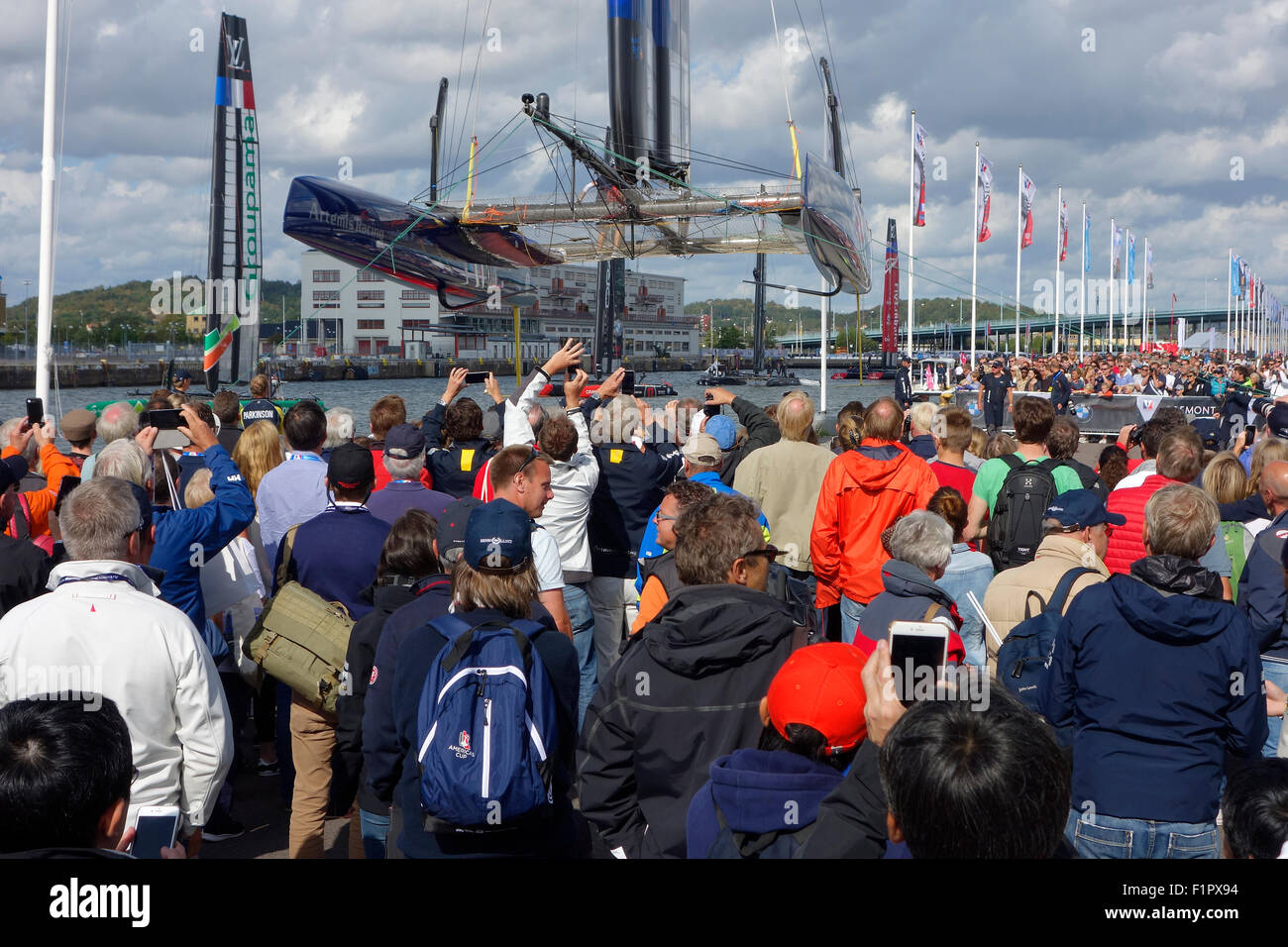 Les gens se rassemblent et se saisir de l'occasion de voir Swedish America's Cup 72 catamaran de classe ci-dessous lorsqu'il est soulevé pour la voile aile r Banque D'Images