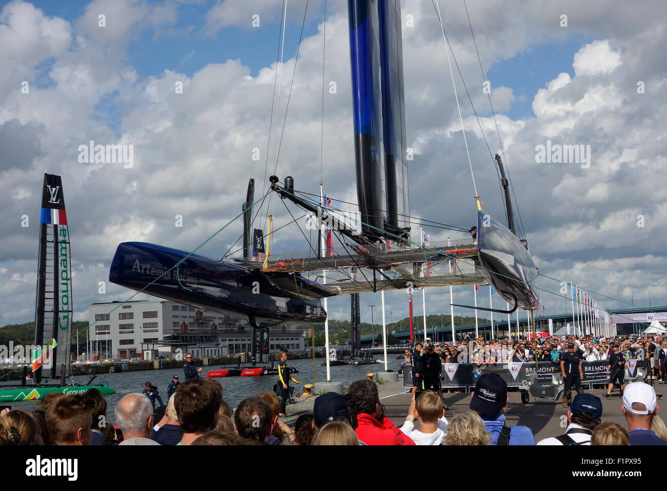 Les gens se rassemblent et se saisir de l'occasion de voir Swedish America's Cup 72 catamaran de classe ci-dessous lorsqu'il est soulevé pour la voile aile r Banque D'Images