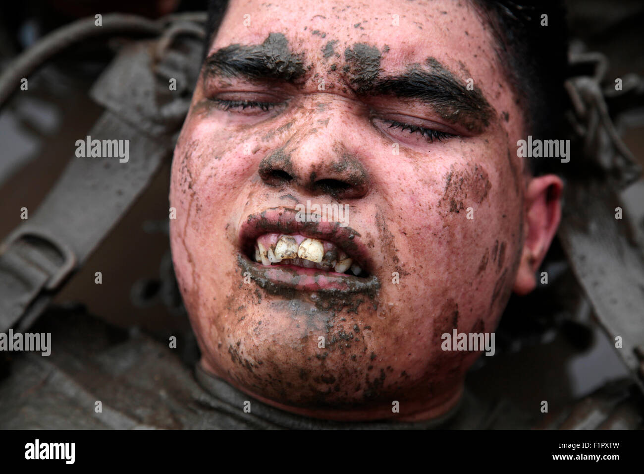 Un marin américain couvert de boue pendant le général commandant's Cup Mud Run de Camp Pendleton, 12 juin 2015 à Oceanside, en Californie. La Mud Run est une course à travers la boue des fosses, des pentes glissantes et nageant à travers la boue épaisse à la ligne d'arrivée. Banque D'Images