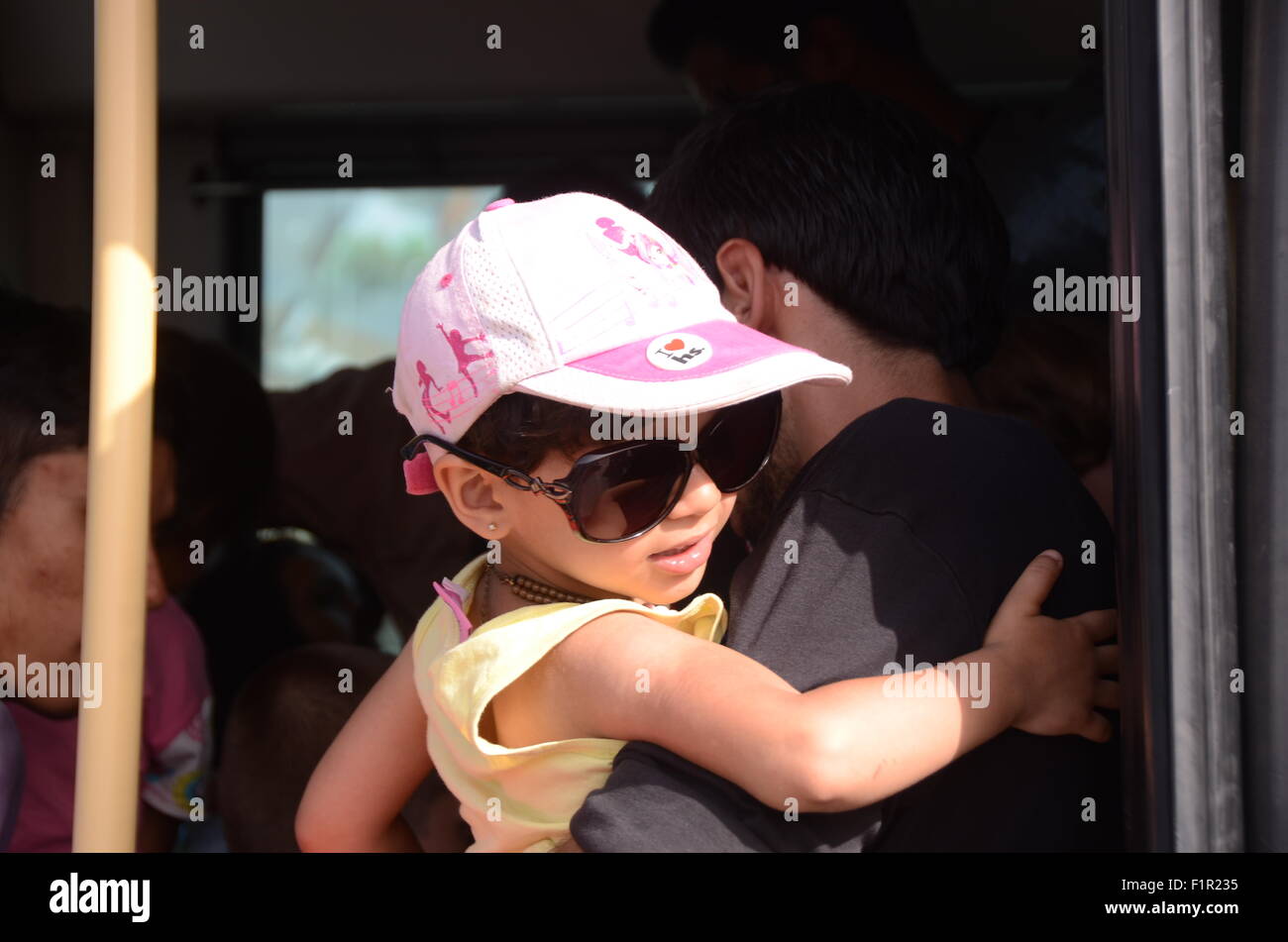 Pirée, Grèce. 06 Sep, 2015. Une fille entre dans un autobus avec son père. Tera Jet ferry est arrivé au port de Pirée transportant 1700 réfugiés syriens de l'île grecque de Lesbos. Crédit : George/Panagakis Pacific Press/Alamy Live News Banque D'Images