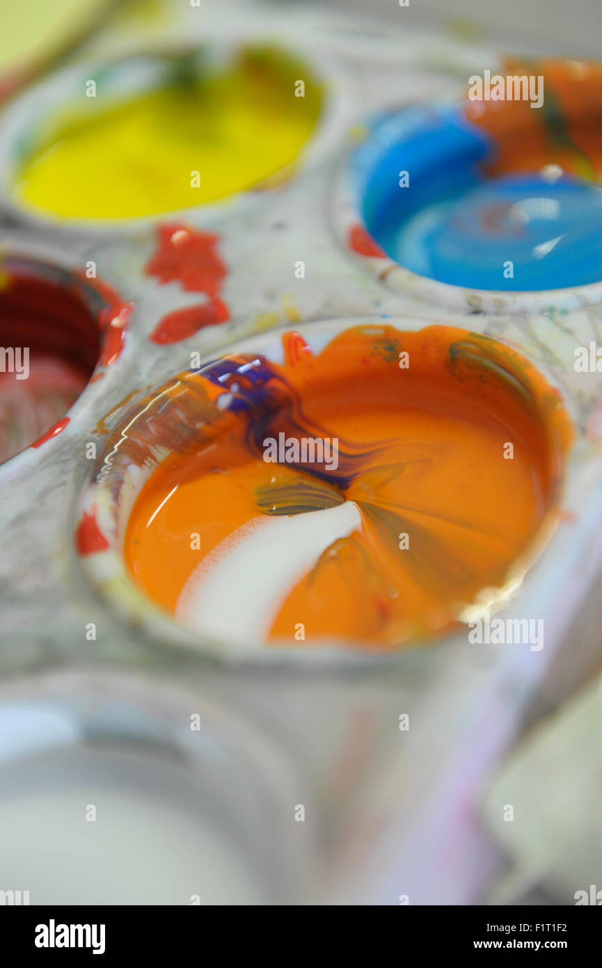 Gouache orange et blanc dans une pallette de peinture liquide Banque D'Images
