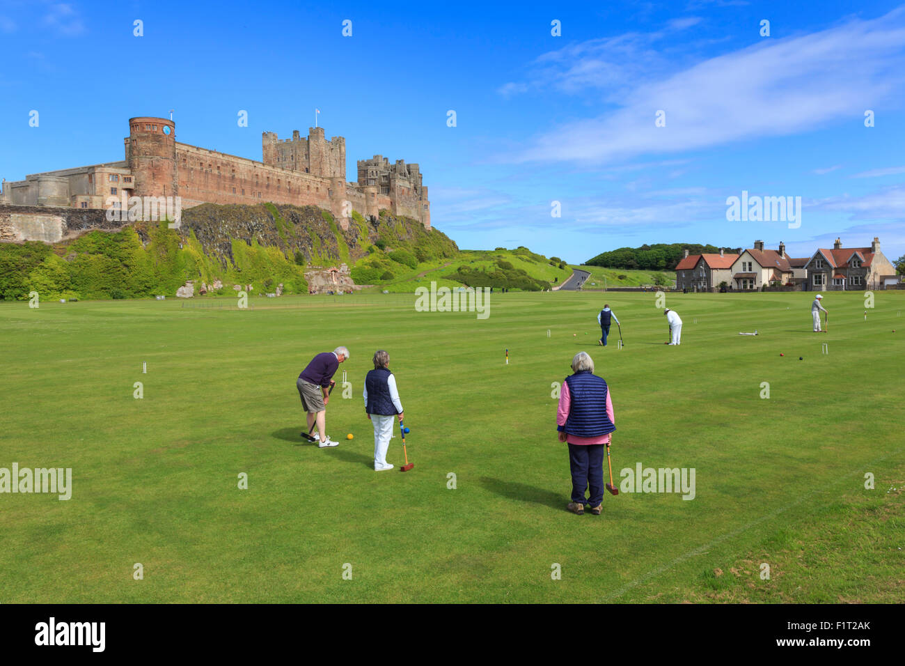 Playing croquet sous Château de Bamburgh sur un bel après-midi d'été, Bamburgh, Northumberland, Angleterre, Royaume-Uni, Europe Banque D'Images