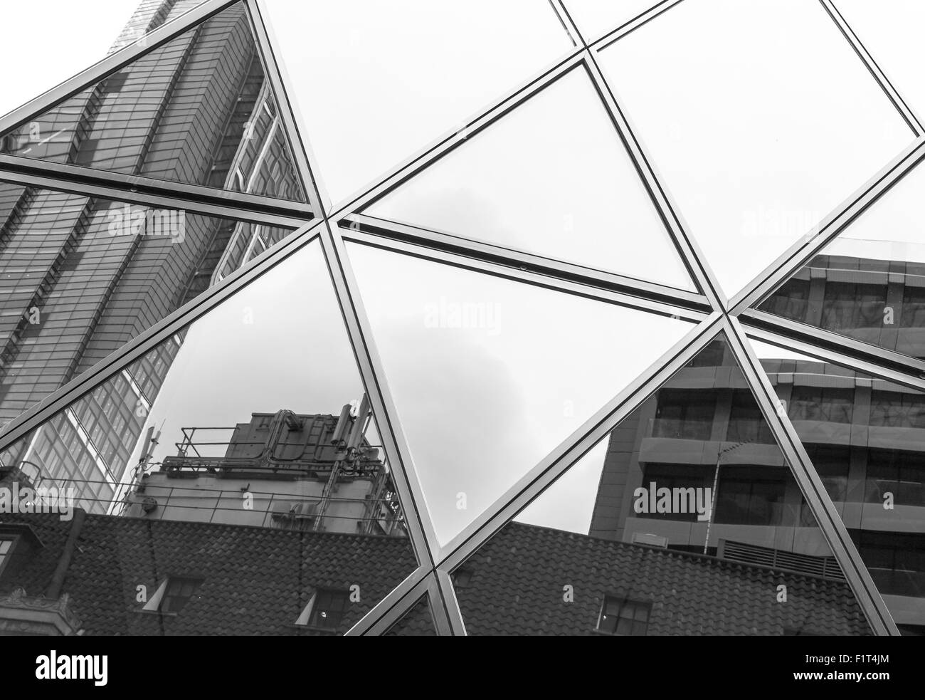 La fenêtre de résumé en forme de triangle réflexions d'un immeuble de bureaux modernes contre un ciel blanc clair Banque D'Images