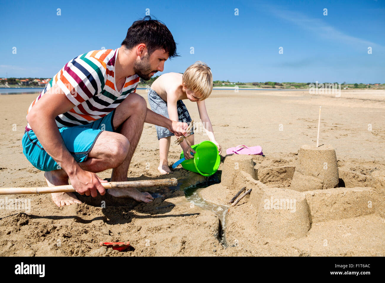 Père et fils sur la plage de sable de décisions Banque D'Images