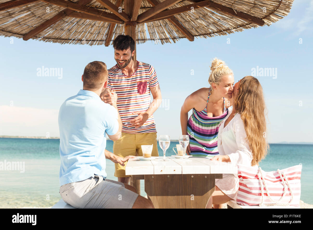 Groupe d'amis de vous détendre dans le bar de la plage Banque D'Images