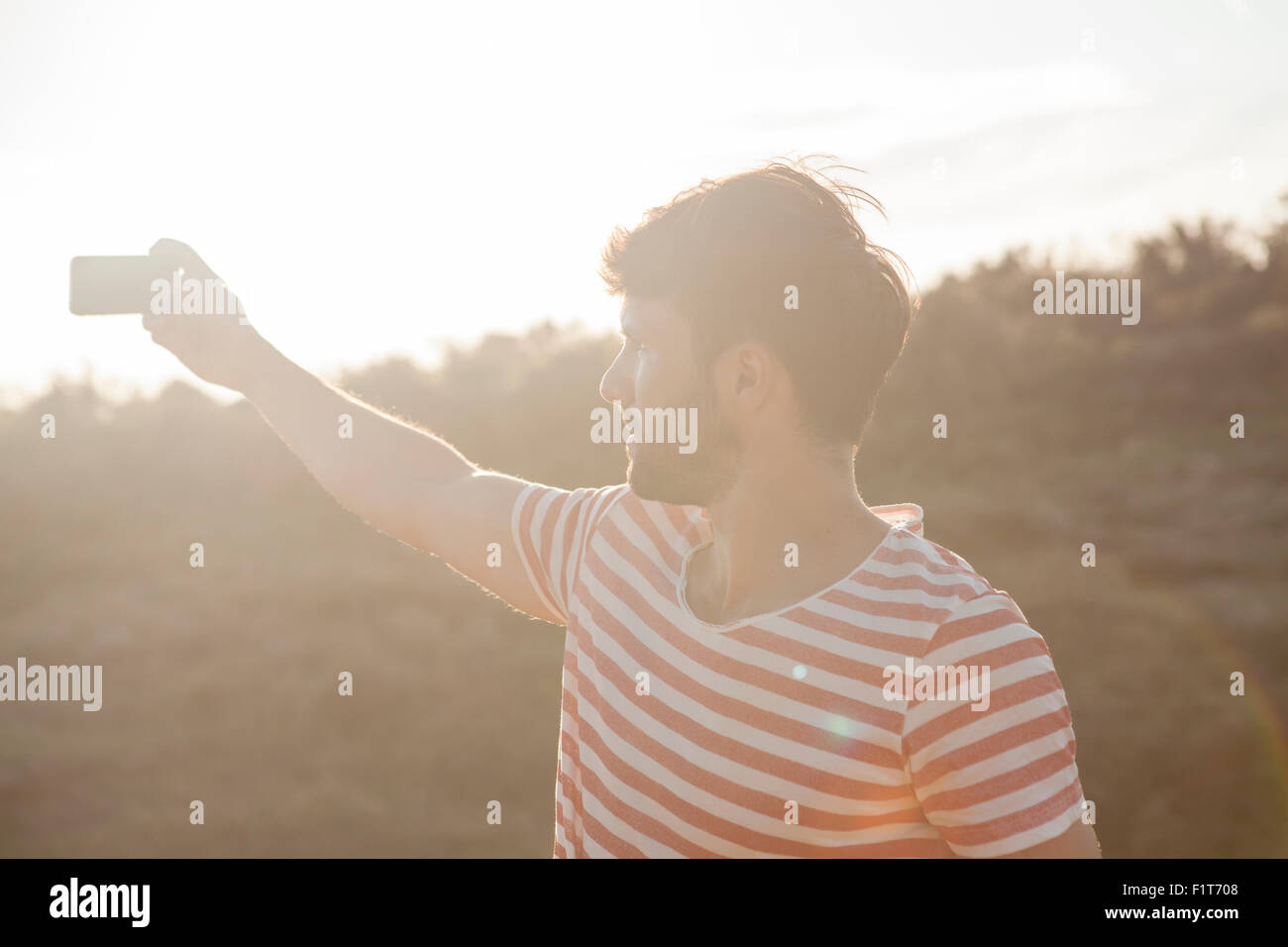 Jeune homme de prendre photo avec smart phone Banque D'Images