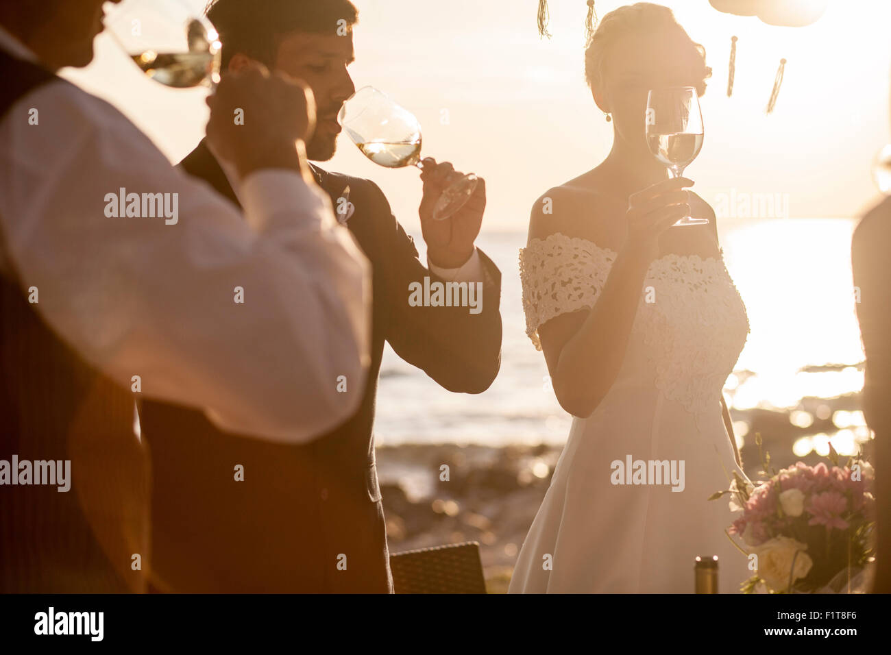 Boire du champagne à réception de mariage sur la plage Banque D'Images