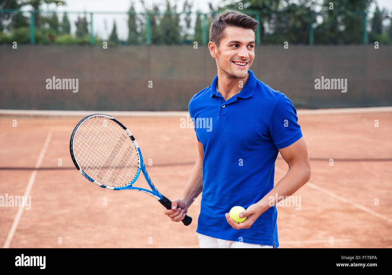 Portrait d'un homme heureux de jouer au tennis en plein air Banque D'Images