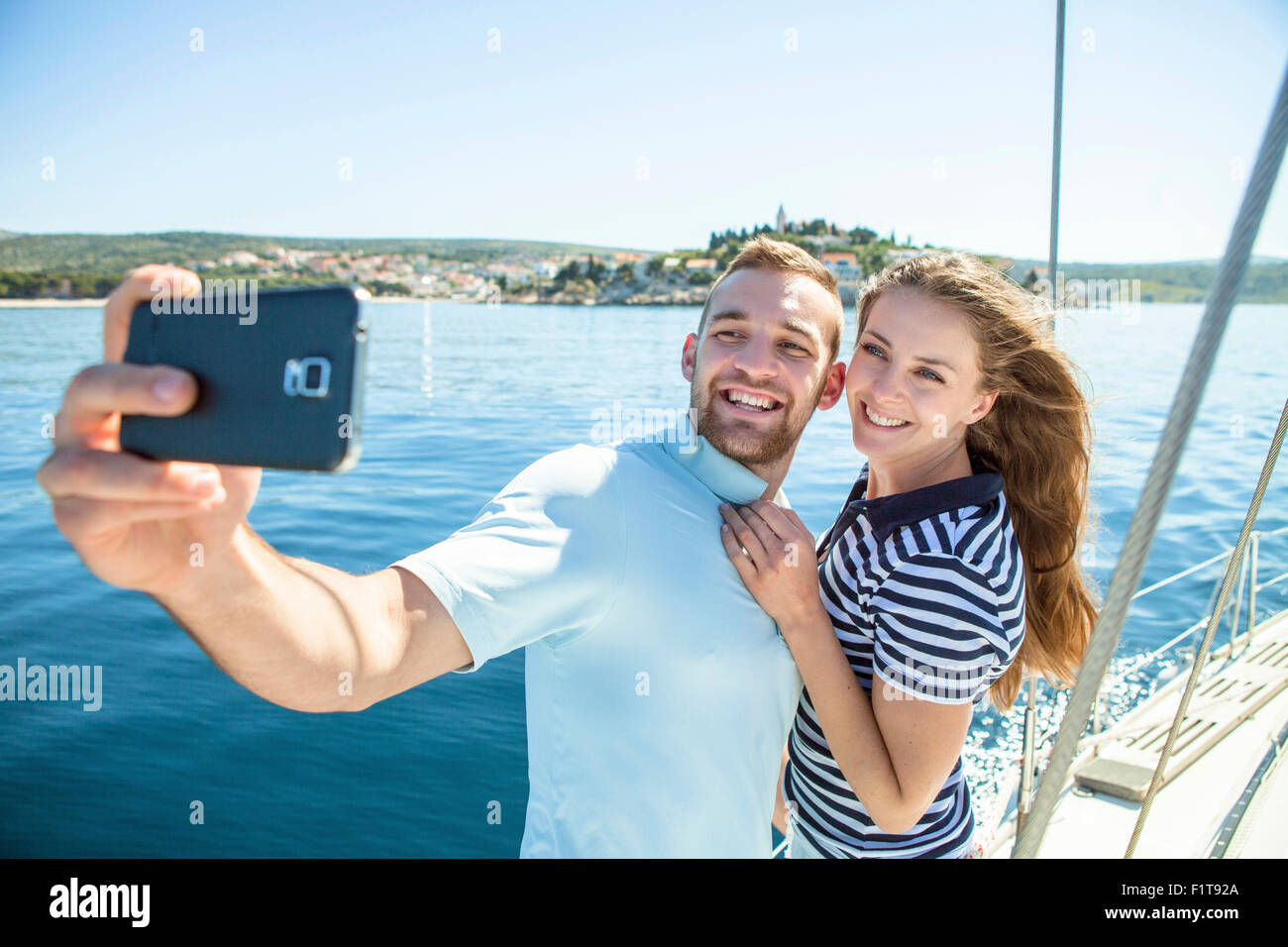 Couple photographing themselves sur voilier, Mer Adriatique Banque D'Images