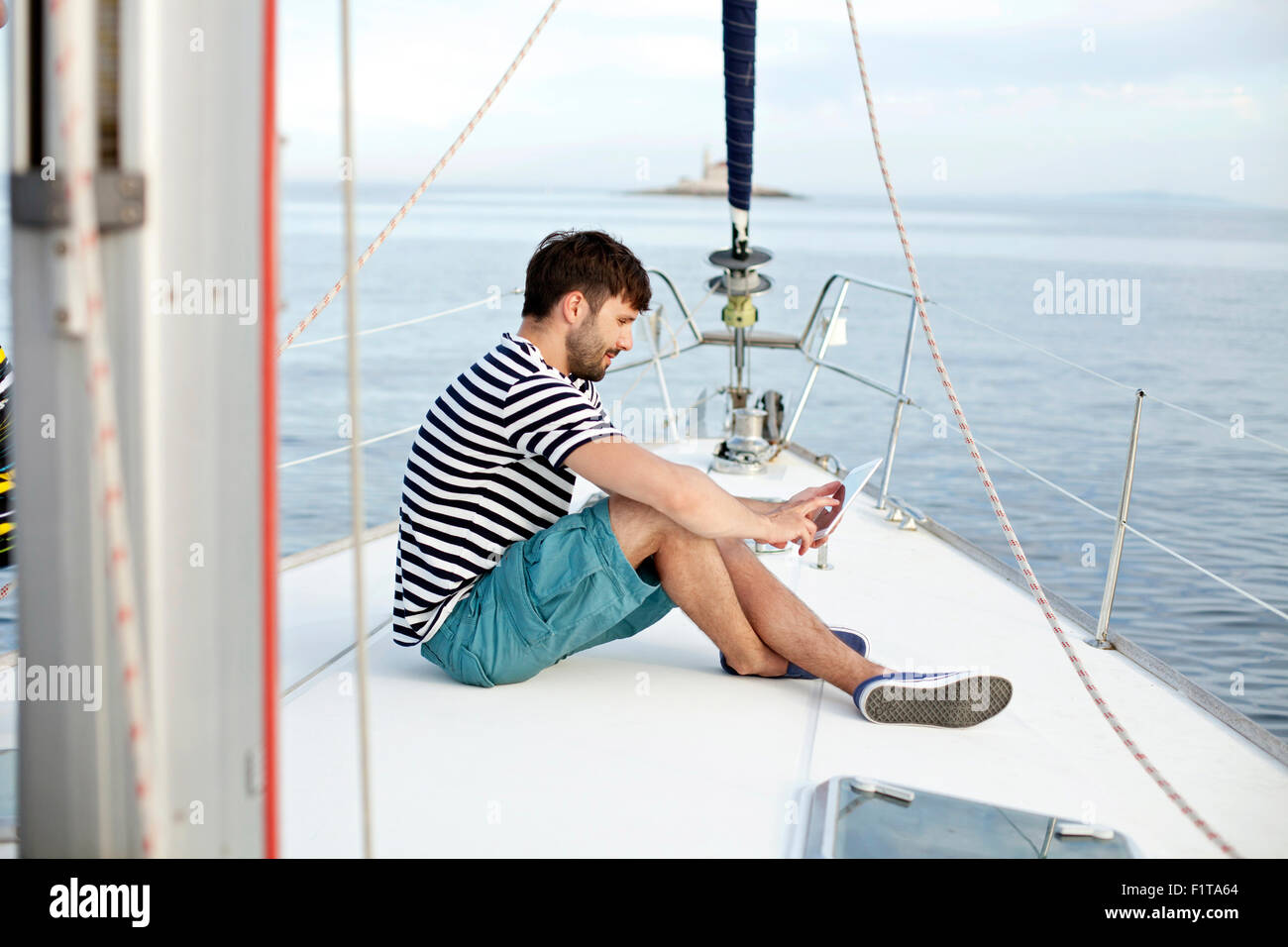 Man using digital tablet sur voilier, Mer Adriatique Banque D'Images