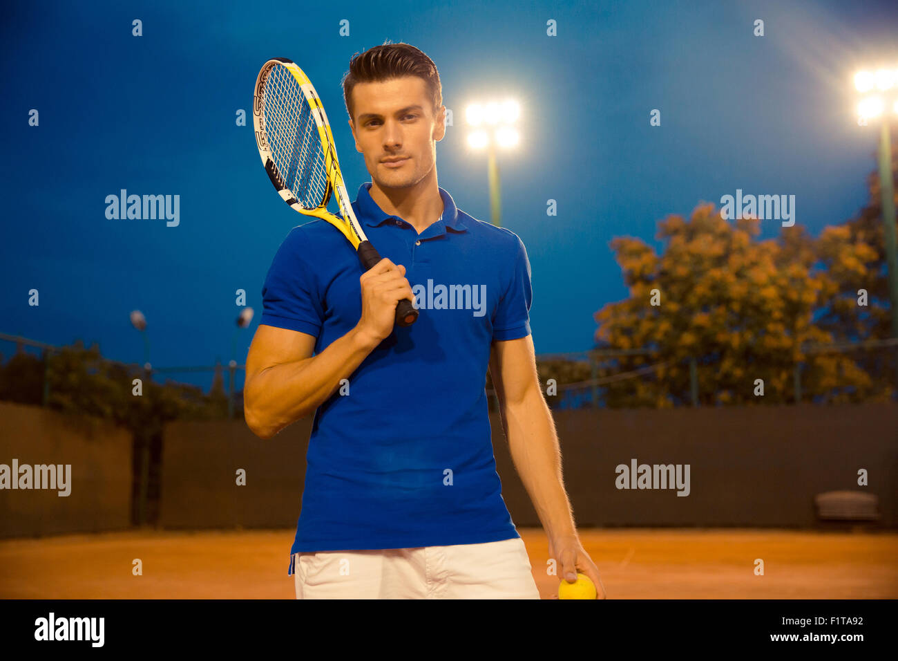 Portrait d'un beau mâle joueur tennis racket permanent avec l'extérieur et looking at camera Banque D'Images