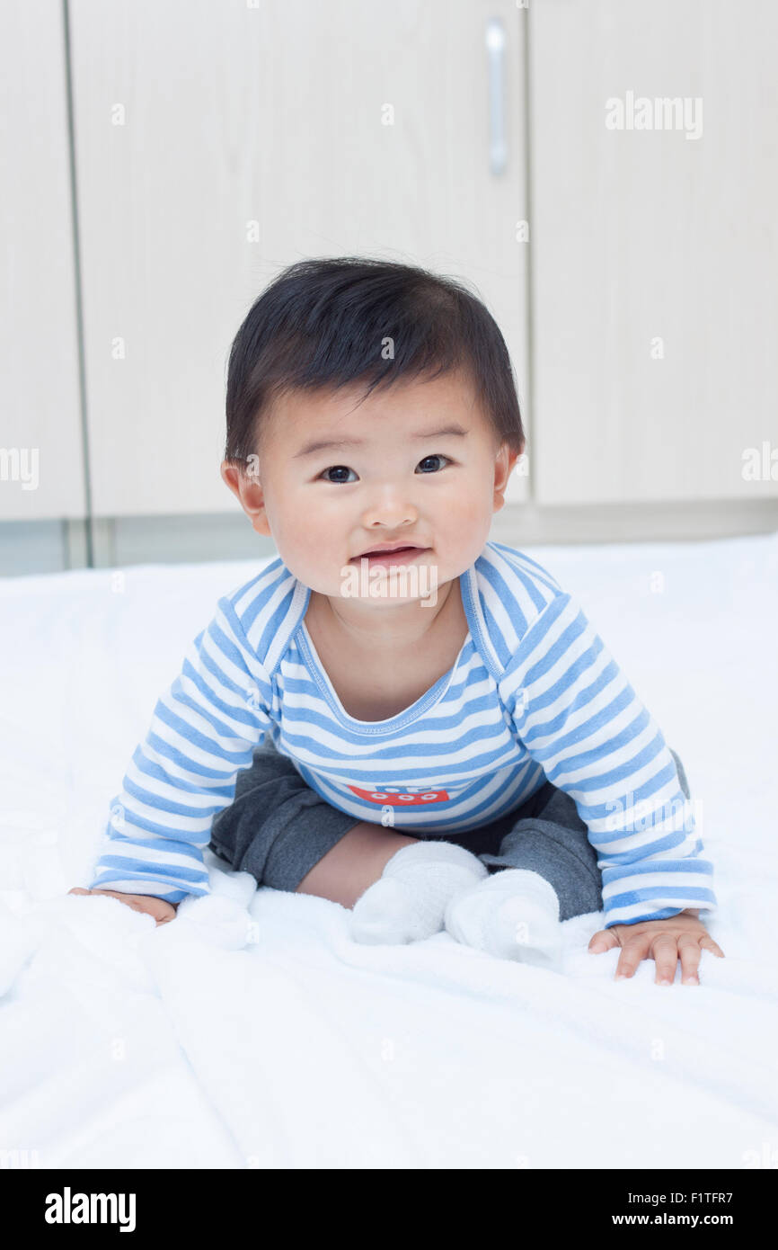 Cute baby boy sitting chinois sur une couverture blanche Banque D'Images