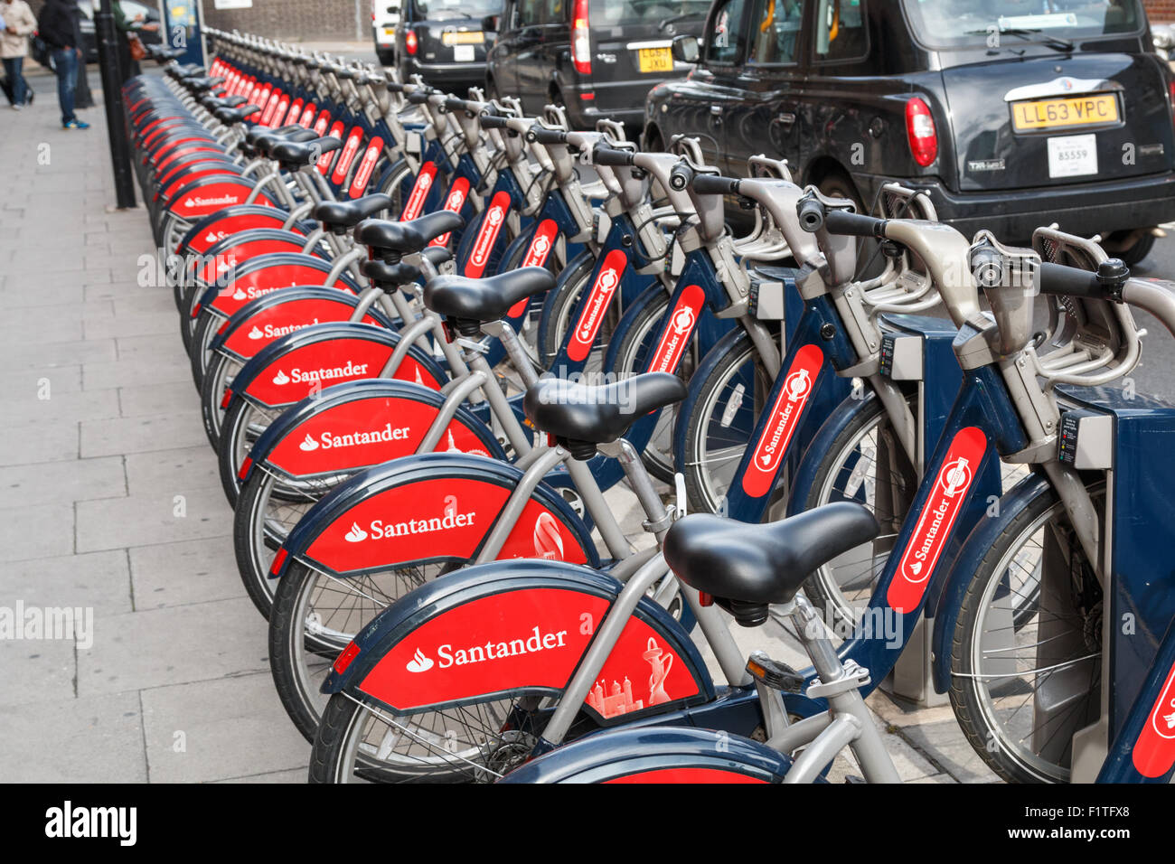 Des vélos de ville ou Boris bikes à côté d'une longue heure de pointe Road à Londres Banque D'Images