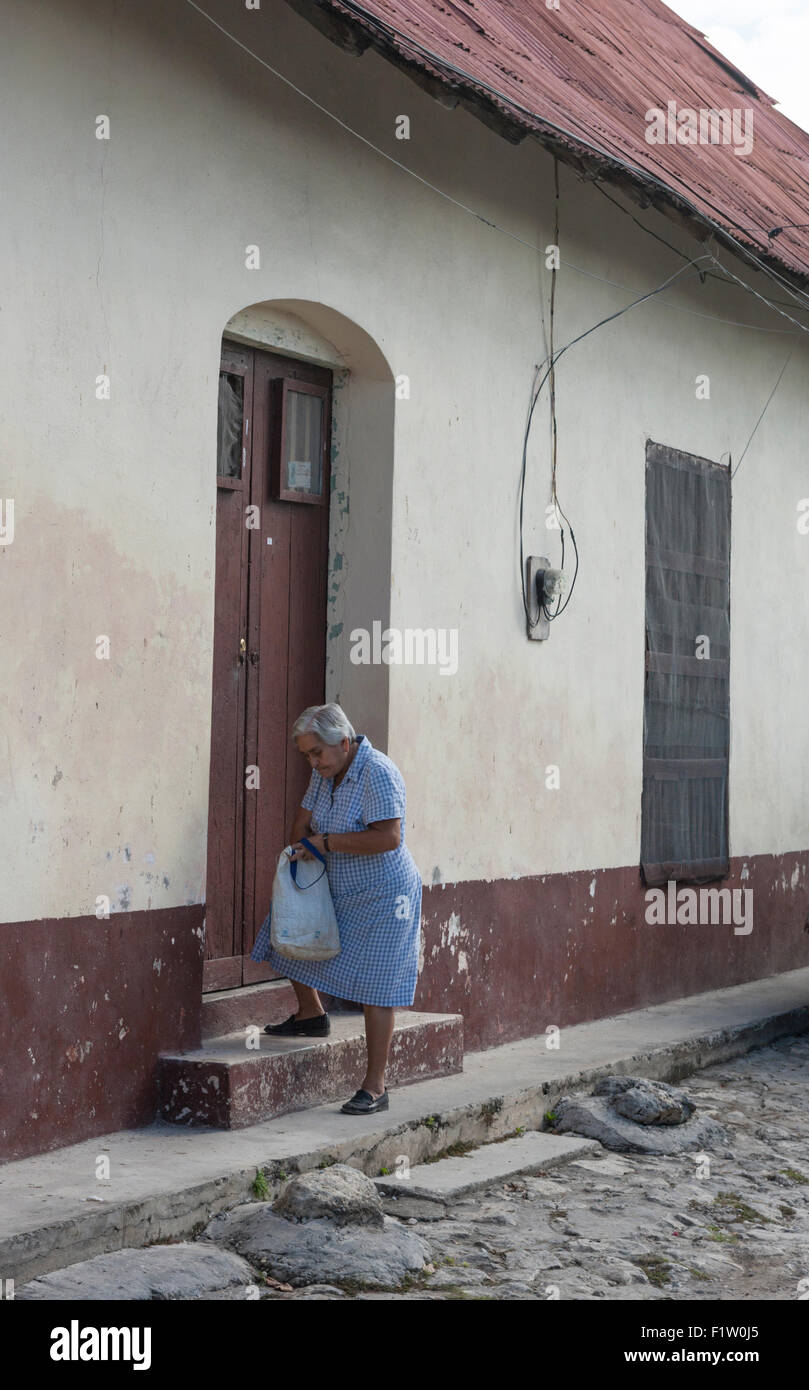Sac femme âgée se prépare à ouvrir la porte de sa maison sur la rue centrale dans Flores Guatemala Banque D'Images